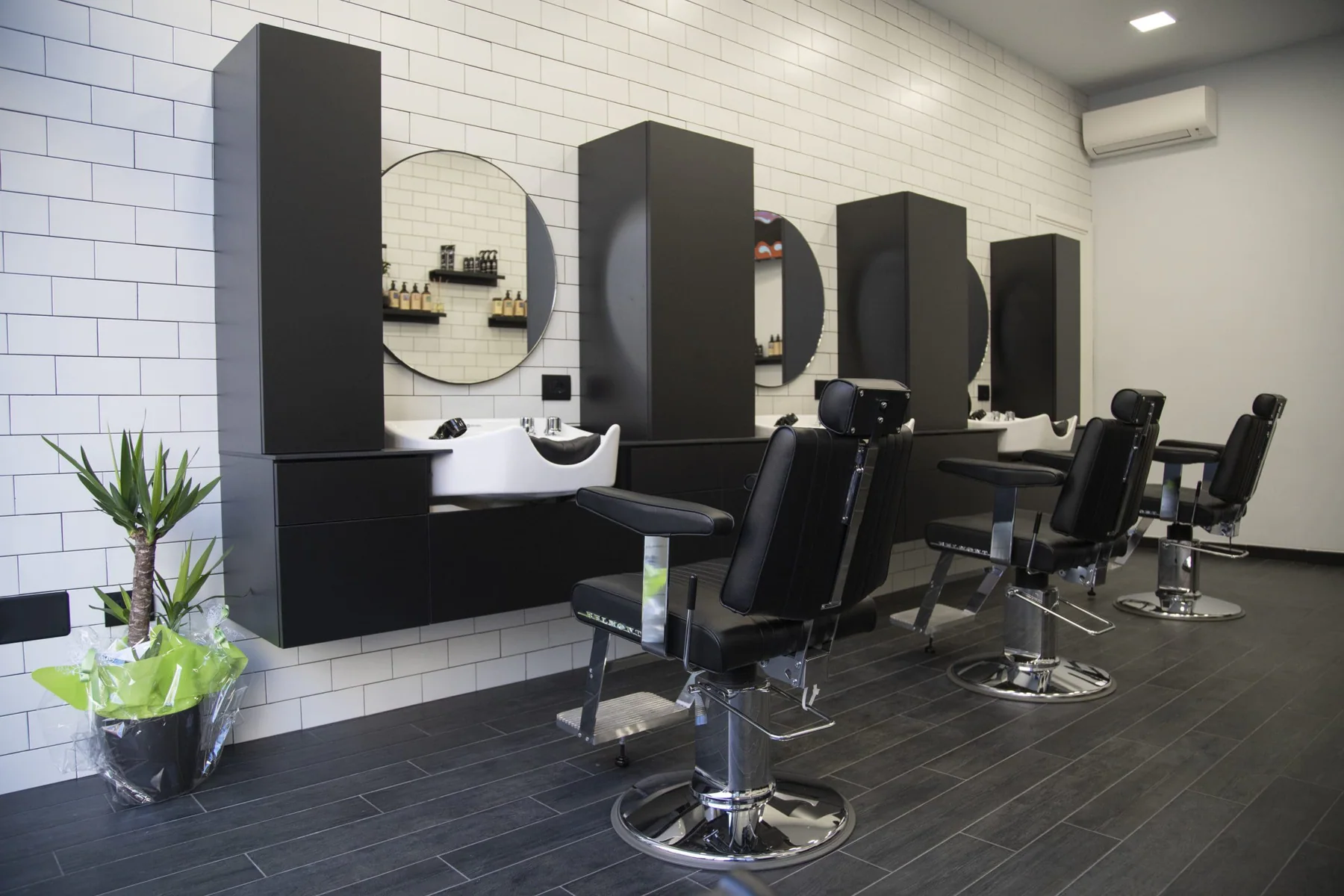 Le postazioni nere e gli specchi circolari di Focus Hair Concept a Milano